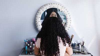 Woman sitting in front of vanity mirror